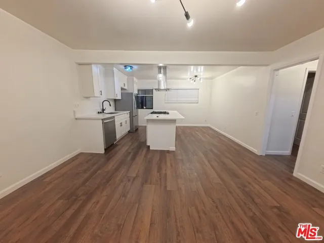 a kitchen with a sink and wooden floor