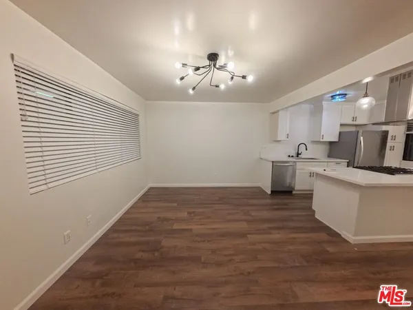 a view of a kitchen with a sink and chandelier