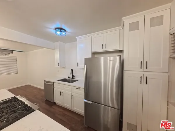 a kitchen with stainless steel appliances granite countertop a refrigerator and a stove