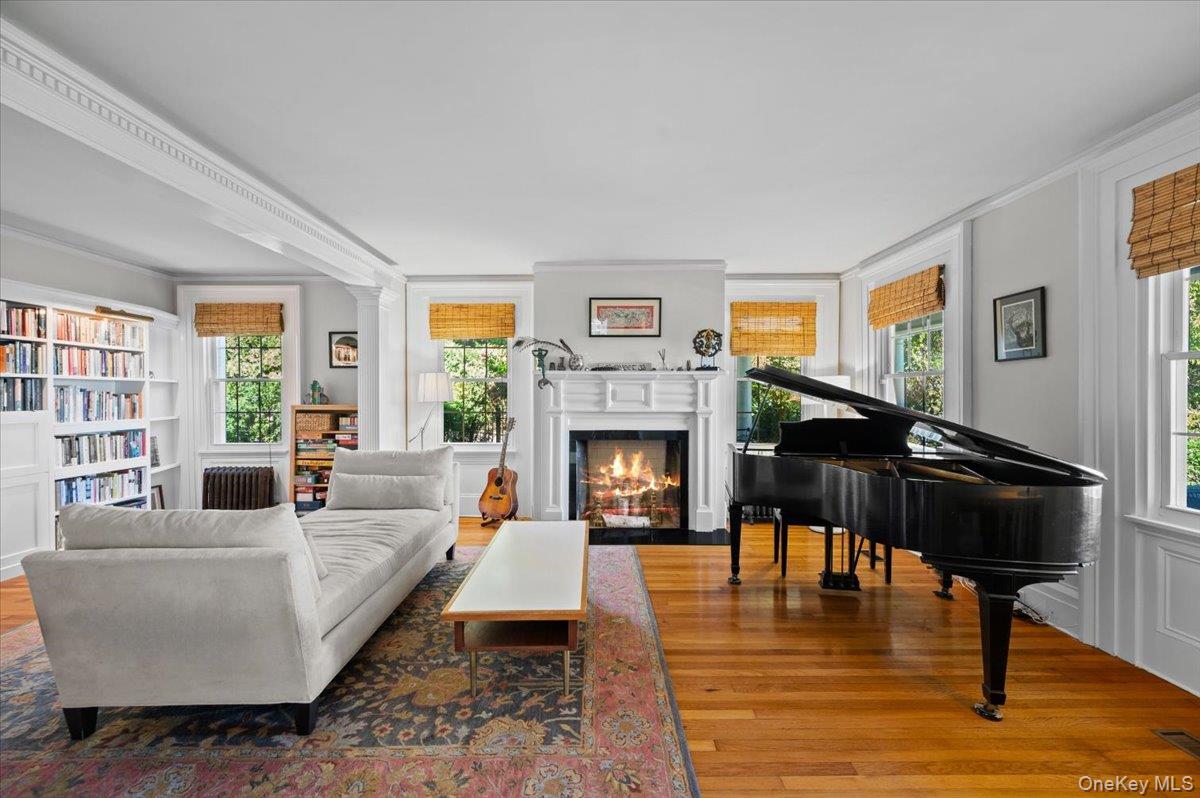 245 River Road Nyack, NY 10960 - Photo 11 of 45 Living area with wood finished floors, healthy amount of natural light, crown molding, a fireplace with flush hearth, and radiator