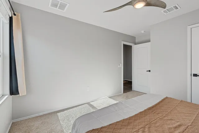 a bedroom with a large bed and a window