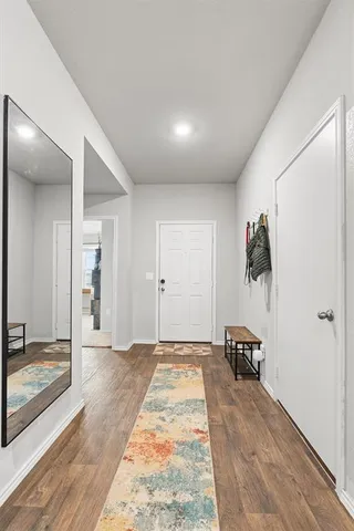 a view of a bedroom with wooden floor and a bathroom