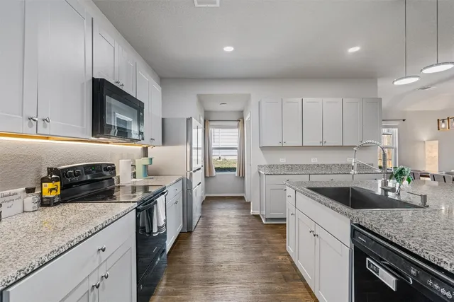 a kitchen with stainless steel appliances granite countertop a sink stove and refrigerator
