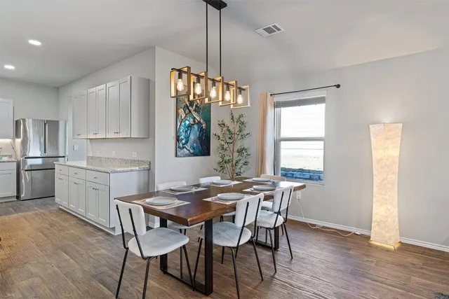 a view of a dining room and livingroom with furniture wooden floor a chandelier