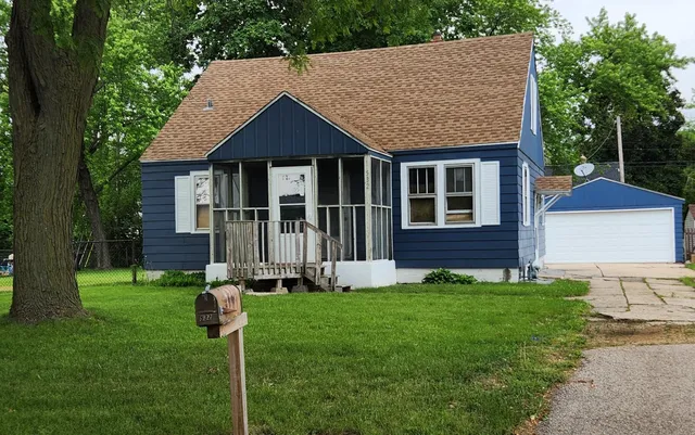 a front view of a house with a yard and trees