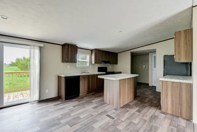 a large kitchen with a stove a sink dishwasher a refrigerator and a oven with wooden floor