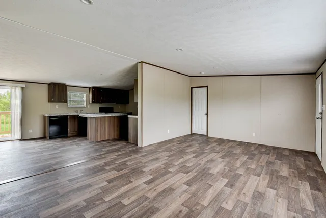 a view of kitchen with kitchen island granite countertop stainless steel appliances and wooden floor