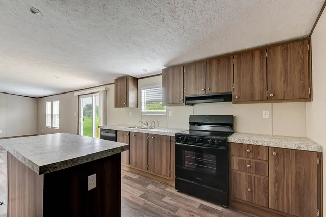 a kitchen with stainless steel appliances granite countertop a stove a sink and a microwave