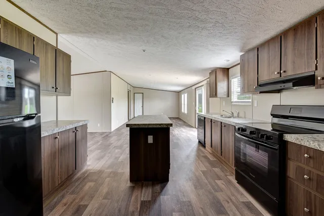 a kitchen with granite countertop a stove top oven and cabinets