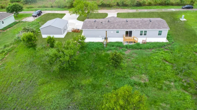 an aerial view of a house with a yard and outdoor seating