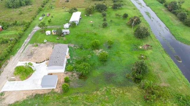 an aerial view of residential houses with outdoor space and trees