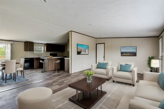 a living room with furniture kitchen view and a flat screen tv