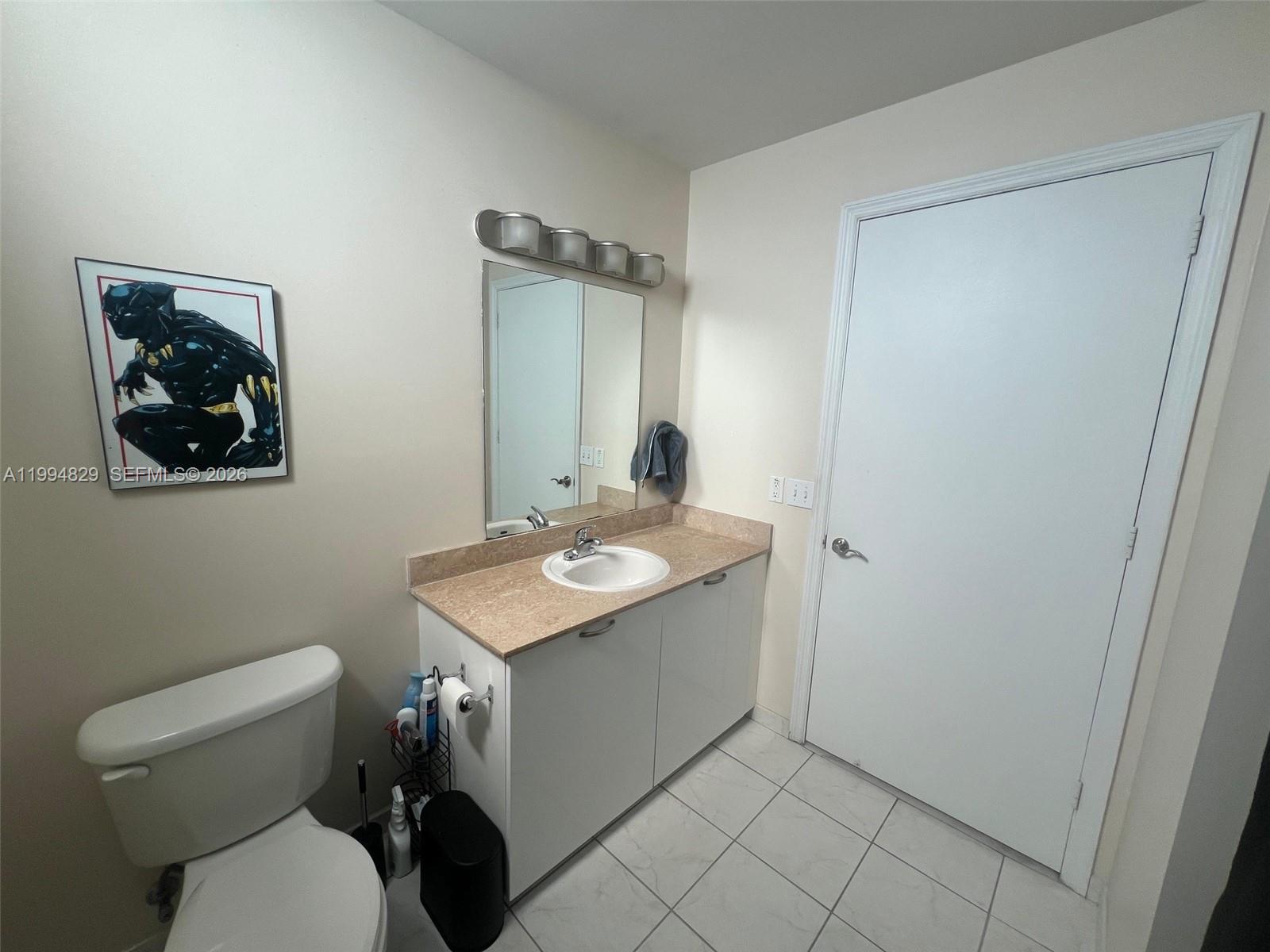 3180 Southwest 22nd Terrace, Unit 607 Miami, FL 33145 - Photo 13 of 18 a bathroom with a toilet sink and mirror