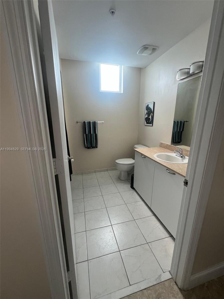 3180 Southwest 22nd Terrace, Unit 607 Miami, FL 33145 - Photo 15 of 18 a bathroom with a sink a toilet and a mirror