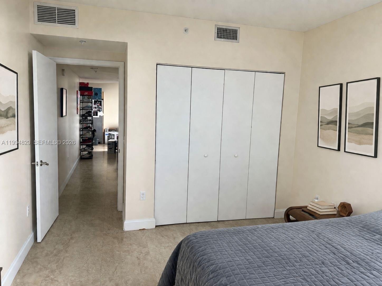 3180 Southwest 22nd Terrace, Unit 607 Miami, FL 33145 - Photo 10 of 18 a bedroom with a bed and a view of en suite bathroom