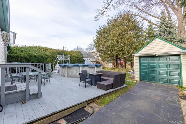 a view of a patio with table and chairs and potted plants with wooden floor and fence