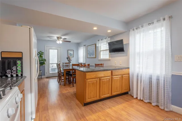 a large white kitchen with lots of counter space and chandelier