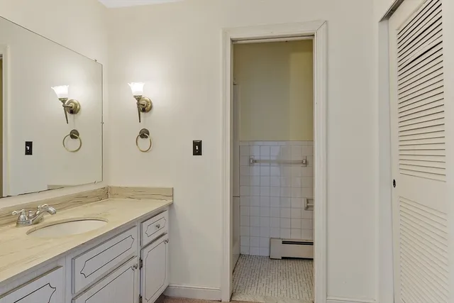 a bathroom with a granite countertop sink a toilet and shower