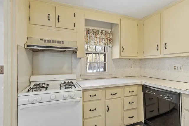 a kitchen with granite countertop white cabinets and white appliances