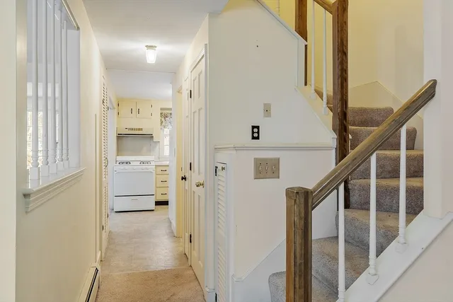 a view of a hallway with white walls and windows