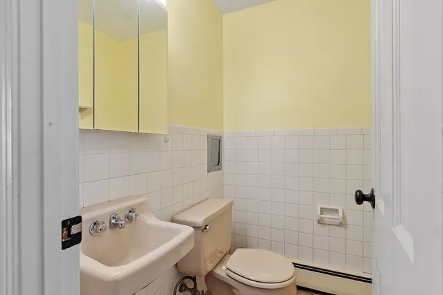 a bathroom with a sink a toilet and mirror