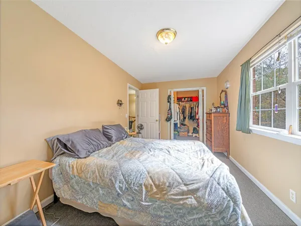 a bed sitting in a bedroom next to a window