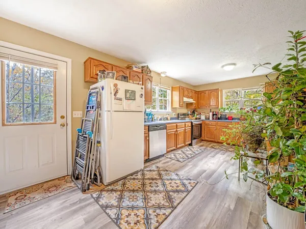 a kitchen with stainless steel appliances a refrigerator and a wooden floor