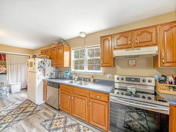 a kitchen with stainless steel appliances granite countertop a stove a sink and a refrigerator