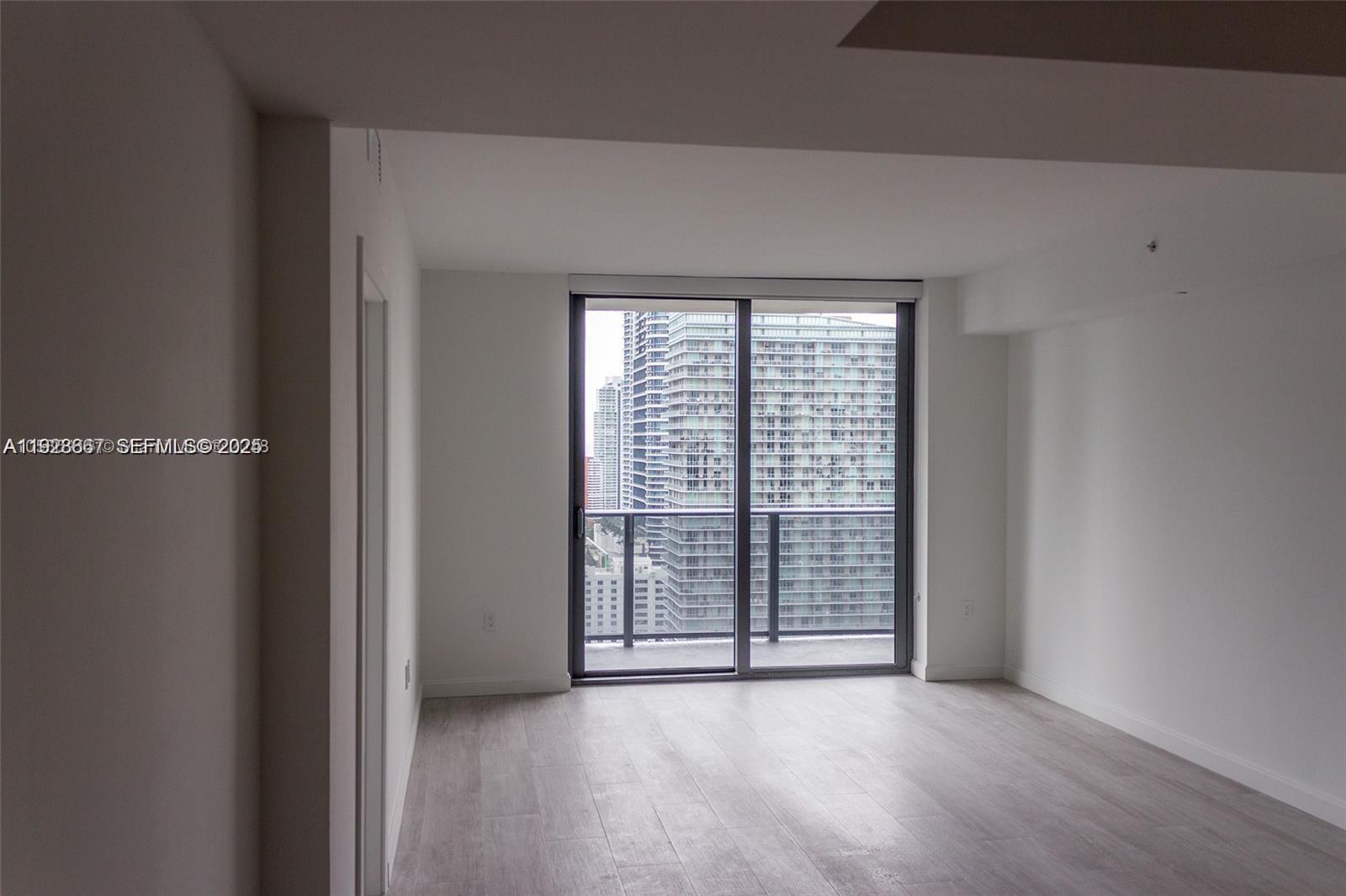 45 Southwest 9th Street, Unit 2805 Miami, FL 33130 - Photo 11 of 16 wooden floor in an empty room with a window