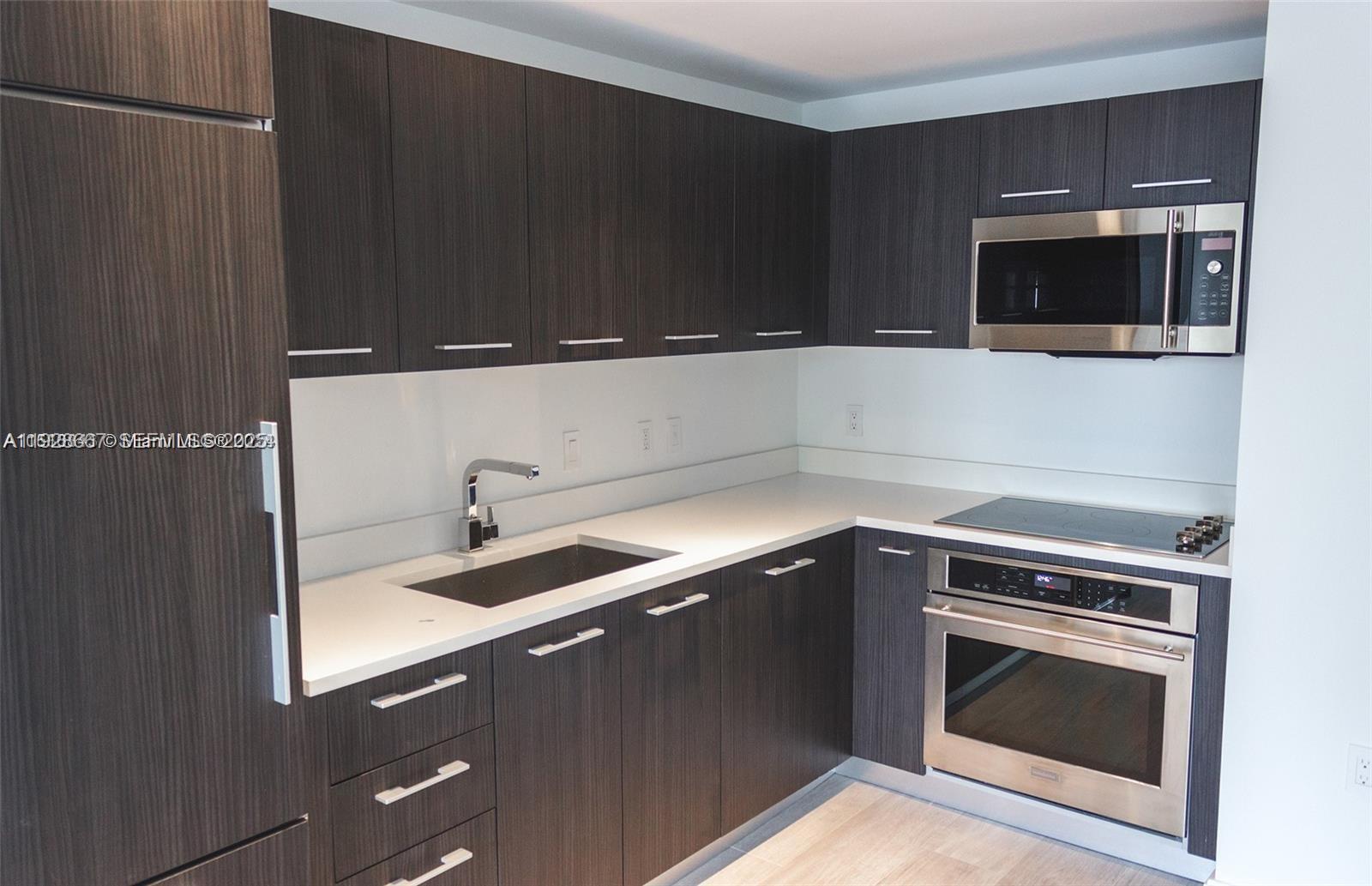 45 Southwest 9th Street, Unit 2805 Miami, FL 33130 - Photo 10 of 16 a kitchen with a sink and stainless steel appliances