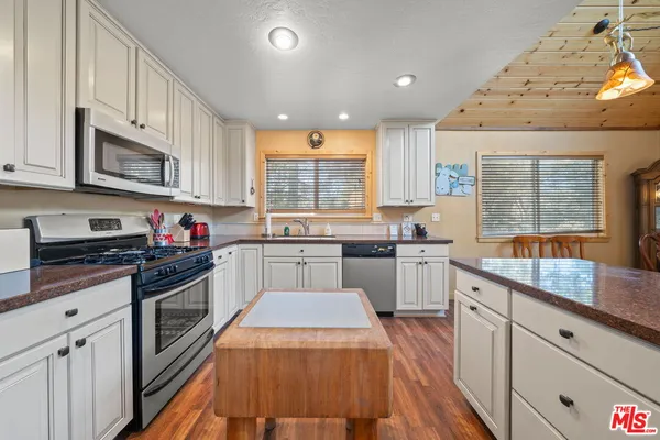 a spacious bedroom with a large bed and a flat tv screen