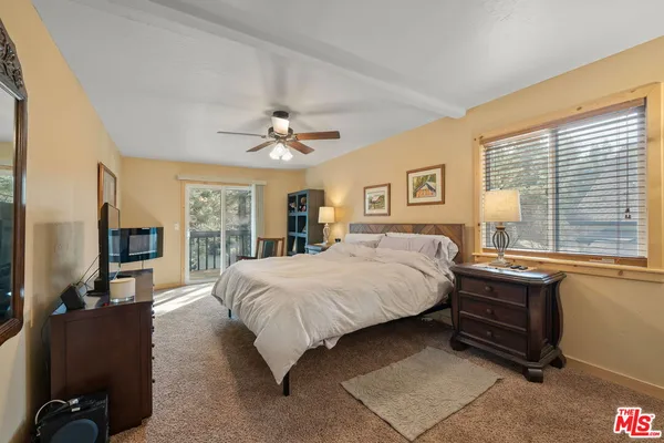 a bedroom with a bed a computer on a table and a chandelier
