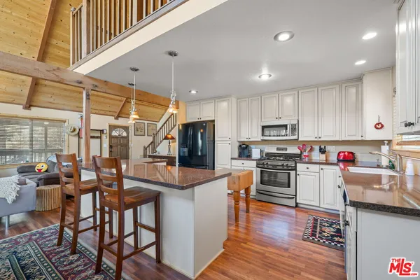 a kitchen with stainless steel appliances granite countertop wooden cabinets granite counter tops and a hard wood floors