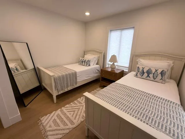 a bedroom with two beds and a mirror