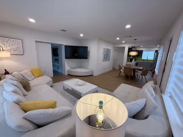 a living room with furniture and a wooden floor