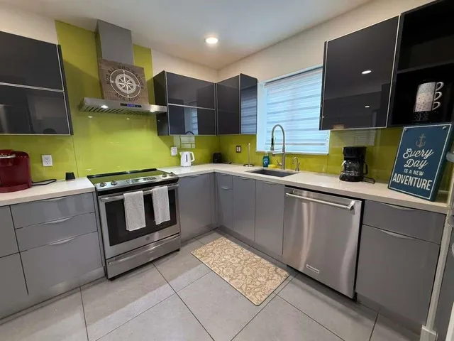 a kitchen with stainless steel appliances granite countertop a sink and a stove