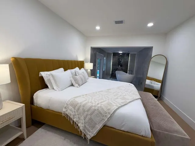 a large bed sitting in a bedroom next to a lamp