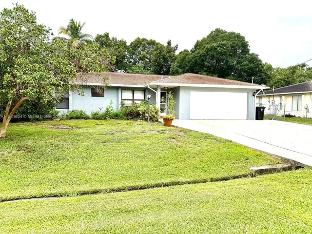 a front view of a house with a garden and yard
