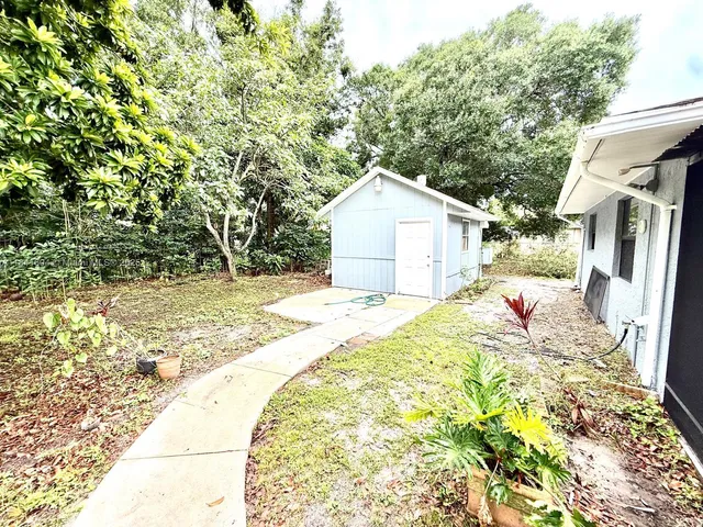 a white house that has tree in front of it