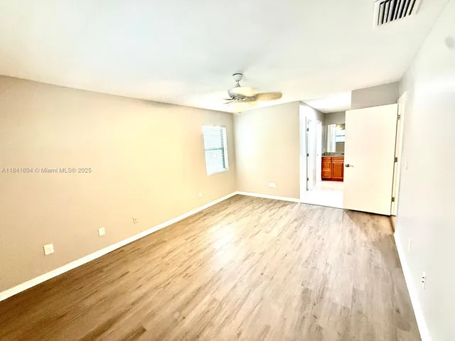 a view of a room with wooden floor and a window