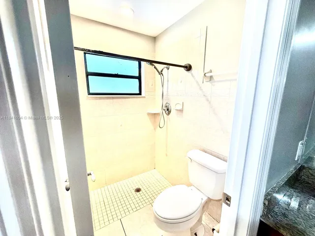 a view of kitchen with granite countertop cabinets stainless steel appliances and a window