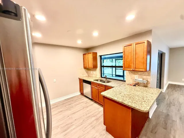 a kitchen with stainless steel appliances granite countertop a refrigerator and a stove