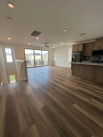 a view of a living room a kitchen with furniture and wooden floor