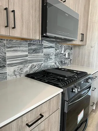 a stove top oven sitting inside of a kitchen