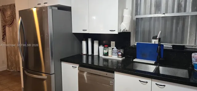 a kitchen with a refrigerator and a sink