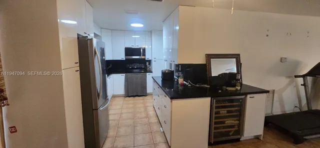 a kitchen with stainless steel appliances a refrigerator and a stove top oven