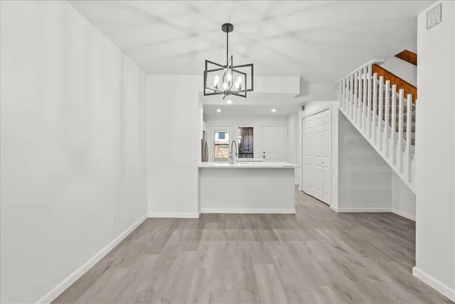 a view of a hallway with wooden floor and staircase