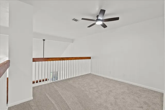 a view of a livingroom with a ceiling fan and window