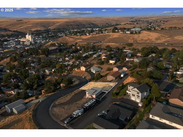 an aerial view of residential building with parking and yard