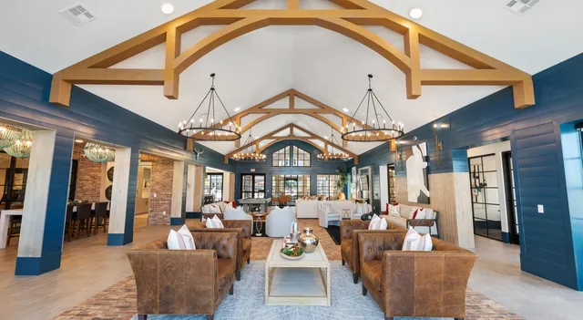 a living room with furniture a large window and a chandelier